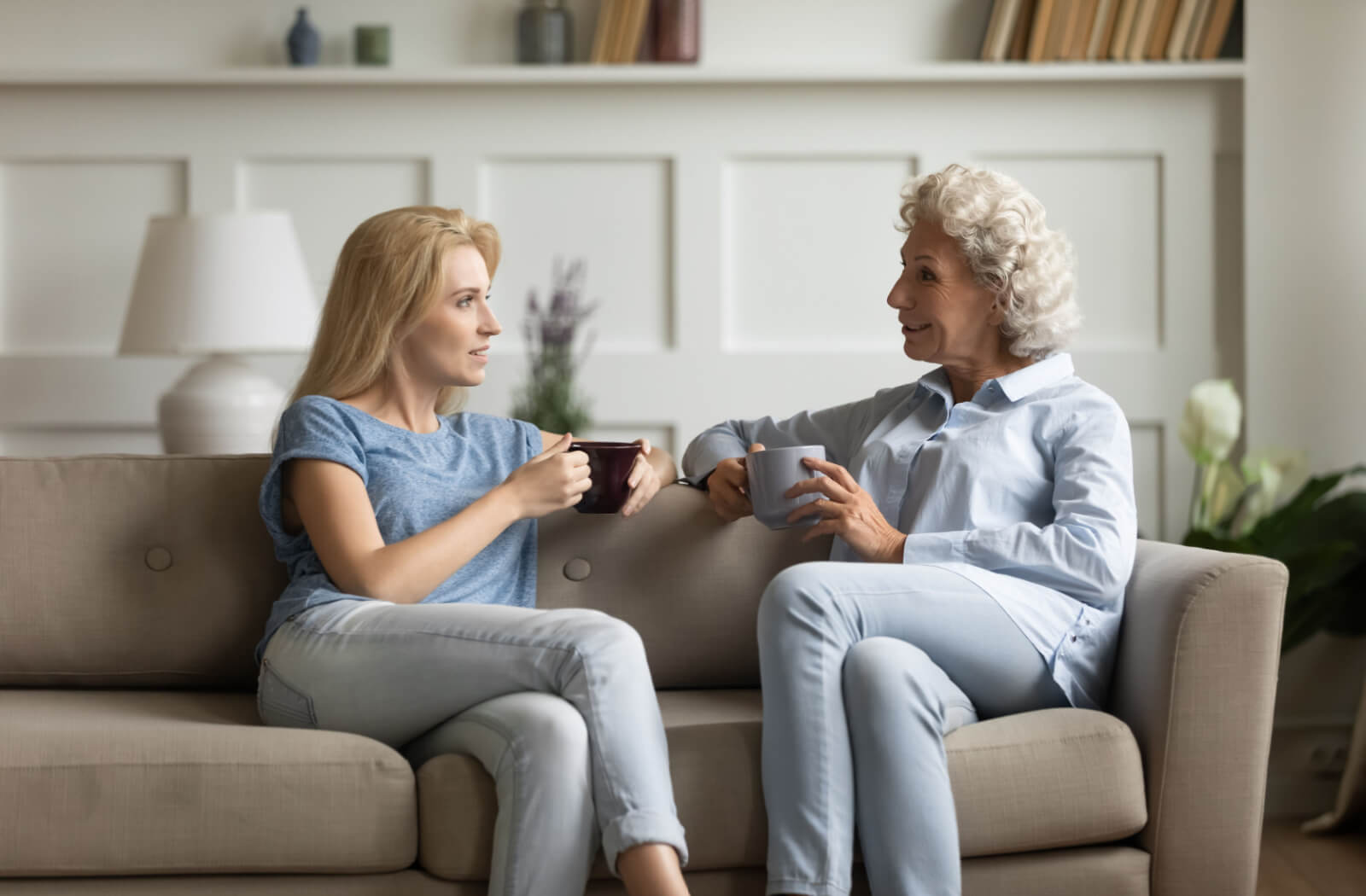 A woman attentively listening to her mother over a cup of coffee.