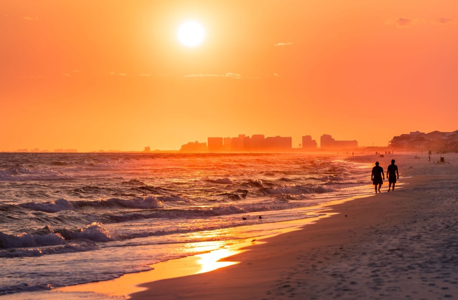 A couple of older adults enjoy a sunset walk on Santa Rosa Beach.