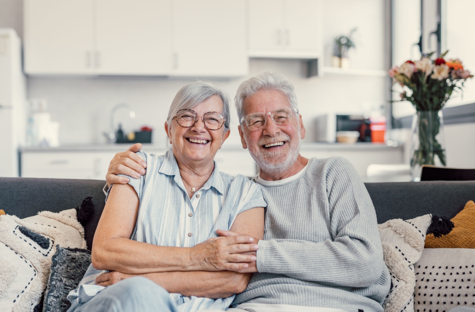 A happy older couple sitting in their living space in memory care.